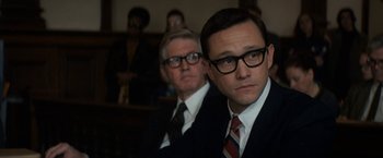 Movie still from “The Trial of the Chicago 7” (2020), directed by Aaron Sorkin – A man in a suit and tie sitting next to another man in a suit; Close Up shot, Low angle
