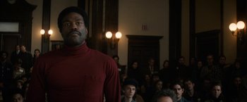 Movie still from “The Trial of the Chicago 7” (2020), directed by Aaron Sorkin – A man standing in front of a group of people; Medium shot, Low angle
