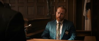 Movie still from “The Trial of the Chicago 7” (2020), directed by Aaron Sorkin – A man in a suit and tie sitting in a courtroom; Medium shot, Over the shoulder angle