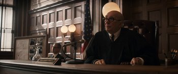 Movie still from “The Trial of the Chicago 7” (2020), directed by Aaron Sorkin – An old man in a court room wearing a judge's robe; Medium shot, Over the shoulder angle