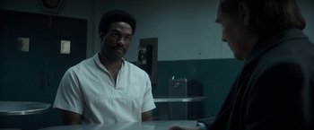 Movie still from “The Trial of the Chicago 7” (2020), directed by Aaron Sorkin – A man sitting at a table in front of another man; Medium shot, Over the shoulder angle