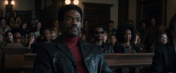 Movie still from “The Trial of the Chicago 7” (2020), directed by Aaron Sorkin – A man standing in front of a group of people in a court room; Medium shot, Low angle