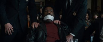 Movie still from “The Trial of the Chicago 7” (2020), directed by Aaron Sorkin – A man with his mouth taped shut is sitting in a chair; Close Up shot, Over the shoulder angle