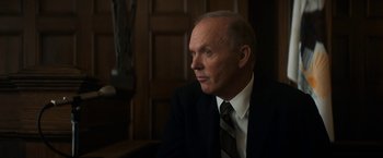 Movie still from “The Trial of the Chicago 7” (2020), directed by Aaron Sorkin – An older man wearing a suit and tie looking to his left; Close Up shot, Over the shoulder angle