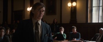 Movie still from “The Trial of the Chicago 7” (2020), directed by Aaron Sorkin – A man wearing a suit and tie in a courtroom; Medium shot, Over the shoulder angle
