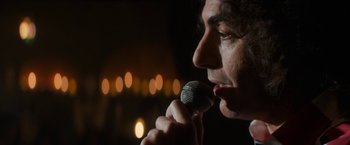 Movie still from “The Trial of the Chicago 7” (2020), directed by Aaron Sorkin – A man holding a microphone up to his mouth; Extreme Close Up shot, Over the shoulder angle