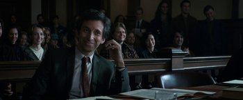 Movie still from “The Trial of the Chicago 7” (2020), directed by Aaron Sorkin – A man sitting in front of a group of people in a courtroom; Medium shot, Over the shoulder angle