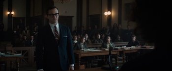 Movie still from “The Trial of the Chicago 7” (2020), directed by Aaron Sorkin – A man standing in front of a group of people in a courtroom; Medium shot, Over the shoulder angle