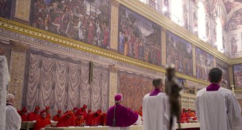 Movie still from “The Two Popes” (2019), directed by Fernando Meirelles – Two men are standing in front of a wall with paintings on it; Extreme Wide shot, High angle