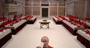 Movie still from “The Two Popes” (2019), directed by Fernando Meirelles – A man holding a piece of paper standing in front of tables; Extreme Wide shot, Overhead angle