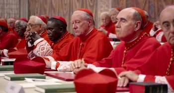 Movie still from “The Two Popes” (2019), directed by Fernando Meirelles – A group of men sitting in front of each other wearing red; Medium shot, High angle