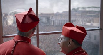 Movie still from “The Two Popes” (2019), directed by Fernando Meirelles – A couple of men wearing red hats looking out a window; Medium shot, High angle