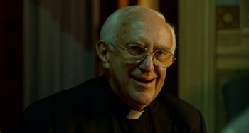 Movie still from “The Two Popes” (2019), directed by Fernando Meirelles – An older man wearing glasses and a priest's outfit; Close Up shot, Over the shoulder angle