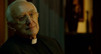 Movie still from “The Two Popes” (2019), directed by Fernando Meirelles – An older man wearing glasses and a priest's outfit; Close Up shot, Over the shoulder angle