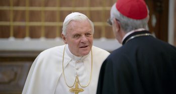 Movie still from “The Two Popes” (2019), directed by Fernando Meirelles – A man in a priest's outfit talking to a man in a cardinal; Close Up shot, Over the shoulder angle