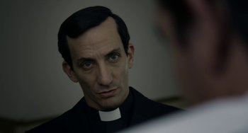 Movie still from “The Two Popes” (2019), directed by Fernando Meirelles – A man wearing a priest's outfit looking into a mirror; Close Up shot, Over the shoulder angle