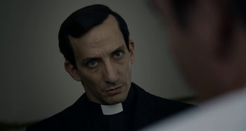 Movie still from “The Two Popes” (2019), directed by Fernando Meirelles – A man wearing a priest's outfit looking at a mirror; Close Up shot, Over the shoulder angle