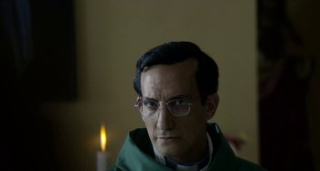 Movie still from “The Two Popes” (2019), directed by Fernando Meirelles – A man wearing glasses and wearing a green robe; Close Up shot, Low angle