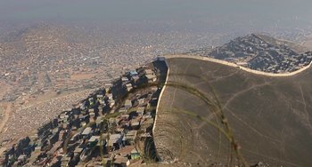 Movie still from “The Two Popes” (2019), directed by Fernando Meirelles – An aerial view of a city and a wall on the side of a hill; Extreme Wide shot, High angle