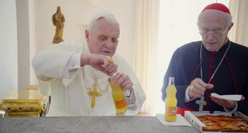 Movie still from “The Two Popes” (2019), directed by Fernando Meirelles – An older man is drinking orange juice from a bottle; Medium shot, High angle