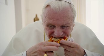 Movie still from “The Two Popes” (2019), directed by Fernando Meirelles – An older man eating a piece of pizza; Extreme Close Up shot, High angle