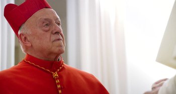 Movie still from “The Two Popes” (2019), directed by Fernando Meirelles – An older man in a red outfit looking up; Close Up shot, Low angle