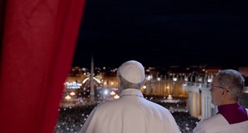 Movie still from “The Two Popes” (2019), directed by Fernando Meirelles – A man in a white coat is looking out over a crowd; Extreme Wide shot, High angle