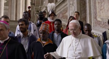 Movie still from “The Two Popes” (2019), directed by Fernando Meirelles – A group of people walking down a street; Medium shot, Over the shoulder angle