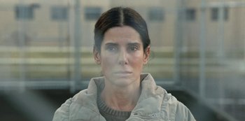 Movie still from “The Unforgivable” (2021), directed by Nora Fingscheidt – A woman is looking out a window at a building; Close Up shot, Over the shoulder angle