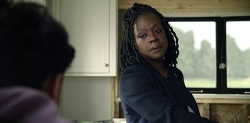 Movie still from “The Unforgivable” (2021), directed by Nora Fingscheidt – A woman with dreadlocks standing in front of a window; Close Up shot, Over the shoulder angle