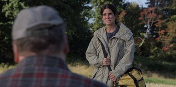 Movie still from “The Unforgivable” (2021), directed by Nora Fingscheidt – A woman holding a backpack while standing in front of a man; Medium shot, Over the shoulder angle