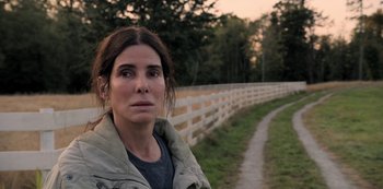 Movie still from “The Unforgivable” (2021), directed by Nora Fingscheidt – A woman standing in front of a white picket fence; Close Up shot, High angle