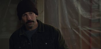 Movie still from “The Unforgivable” (2021), directed by Nora Fingscheidt – A man wearing a hat and a jacket; Close Up shot, Over the shoulder angle