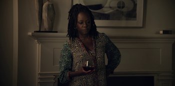 Movie still from “The Unforgivable” (2021), directed by Nora Fingscheidt – A woman holding a candle in her hands; Medium shot, Over the shoulder angle