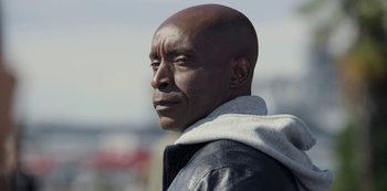 Movie still from “The Unforgivable” (2021), directed by Nora Fingscheidt – A man with a black leather jacket and a white hoodie; Close Up shot, Low angle