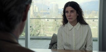 Movie still from “The Unforgivable” (2021), directed by Nora Fingscheidt – A woman sitting at a table in front of a window; Close Up shot, Over the shoulder angle