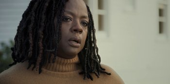 Movie still from “The Unforgivable” (2021), directed by Nora Fingscheidt – A person with dreadlocks wearing a sweater; Close Up shot, Low angle