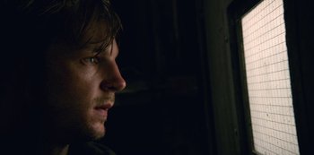 Movie still from “The Unforgivable” (2021), directed by Nora Fingscheidt – A man's face in the dark; Close Up shot, Over the shoulder angle