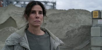 Movie still from “The Unforgivable” (2021), directed by Nora Fingscheidt – A woman in a gray shirt and a gray jacket; Close Up shot, High angle