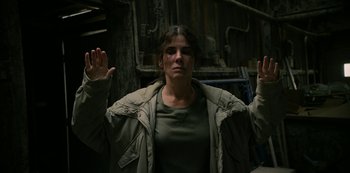 Movie still from “The Unforgivable” (2021), directed by Nora Fingscheidt – A woman is holding her hands up in the air; Medium shot, Low angle