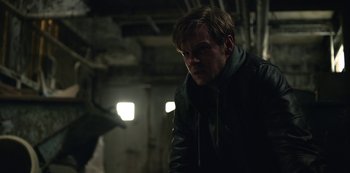 Movie still from “The Unforgivable” (2021), directed by Nora Fingscheidt – A man standing in the dark in a building; Close Up shot, Over the shoulder angle