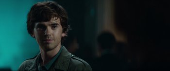 Movie still from “The Vault” (2021), directed by Jaume Balagueró – A person wearing a green jacket; Close Up shot, Over the shoulder angle