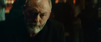 Movie still from “The Vault” (2021), directed by Jaume Balagueró – An older man with a beard and a mustache; Close Up shot, Low angle