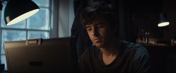 Movie still from “The Vault” (2021), directed by Jaume Balagueró – A man sitting in front of a computer screen; Close Up shot, Over the shoulder angle