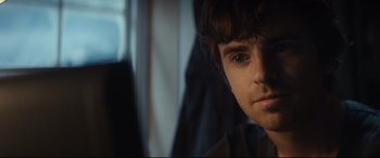 Movie still from “The Vault” (2021), directed by Jaume Balagueró – A man's face in a dark room; Close Up shot, Over the shoulder angle