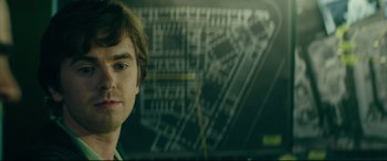 Movie still from “The Vault” (2021), directed by Jaume Balagueró – A person with a map in the background; Close Up shot, Over the shoulder angle