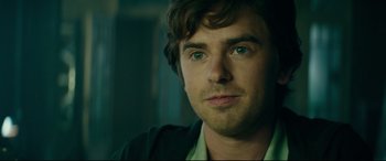 Movie still from “The Vault” (2021), directed by Jaume Balagueró – A person wearing a green shirt; Close Up shot, Over the shoulder angle