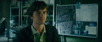 Movie still from “The Vault” (2021), directed by Jaume Balagueró – A man standing in front of a map in a room; Close Up shot, Over the shoulder angle