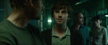 Movie still from “The Vault” (2021), directed by Jaume Balagueró – A man in a green shirt is looking at another man in a green shirt; Close Up shot, Over the shoulder angle