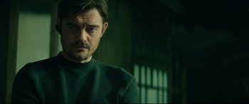 Movie still from “The Vault” (2021), directed by Jaume Balagueró – A person wearing a green shirt; Close Up shot, Low angle